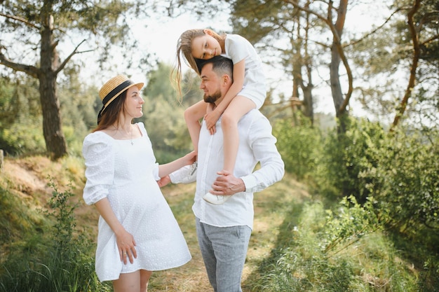 Mujer embarazada con su familia luciendo feliz