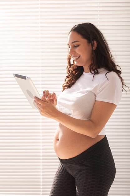 Mujer embarazada con tableta digital