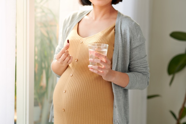 Mujer embarazada tomando píldoras de vitamina