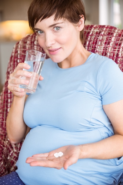 Mujer embarazada tomando una tableta de vitamina