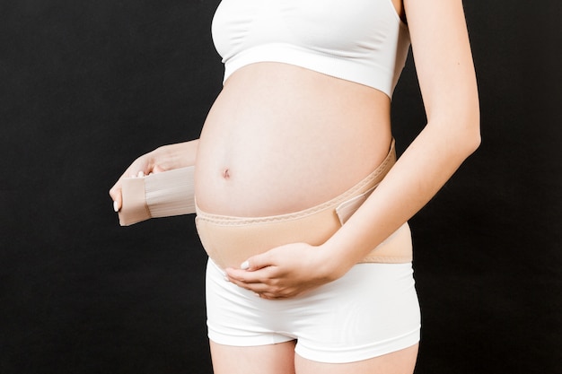 Mujer embarazada usando un cinturón abdominal