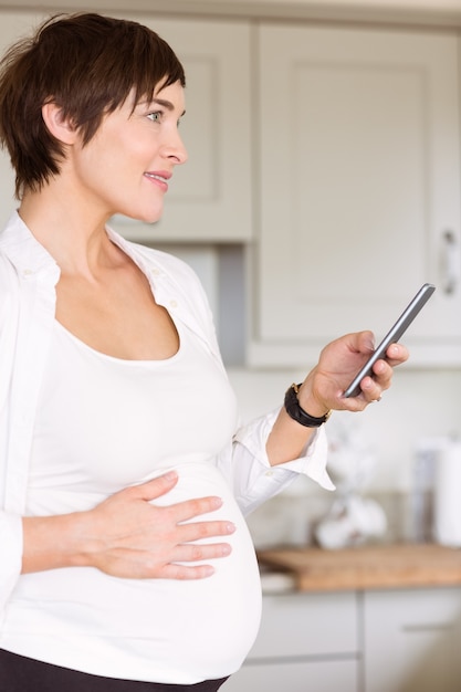 Mujer embarazada usando su teléfono inteligente