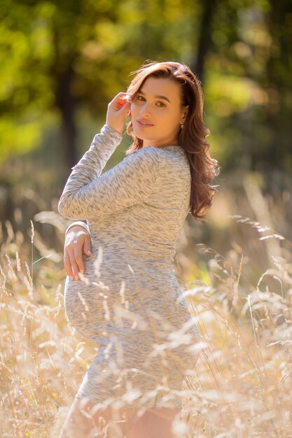 mujer embarazada con vestido posando en la naturaleza