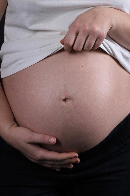 Foto mujer embarazada, vientre, embarazo, concepto, aislado, en, fondo negro, barriga embarazada, primer plano