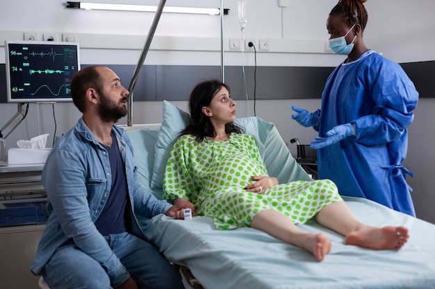 Mujer con embarazo hablando con la enfermera de obstetricia