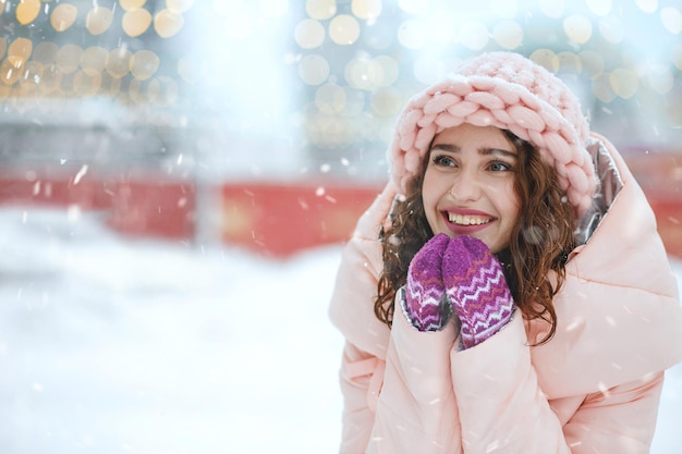 Mujer emocionada disfrutando de las nevadas en la feria de Navidad. Espacio para texto