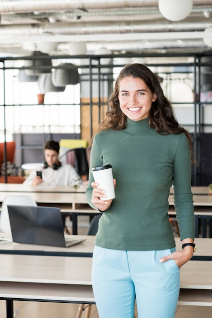 Mujer emocionada en la oficina con diseño contemporáneo