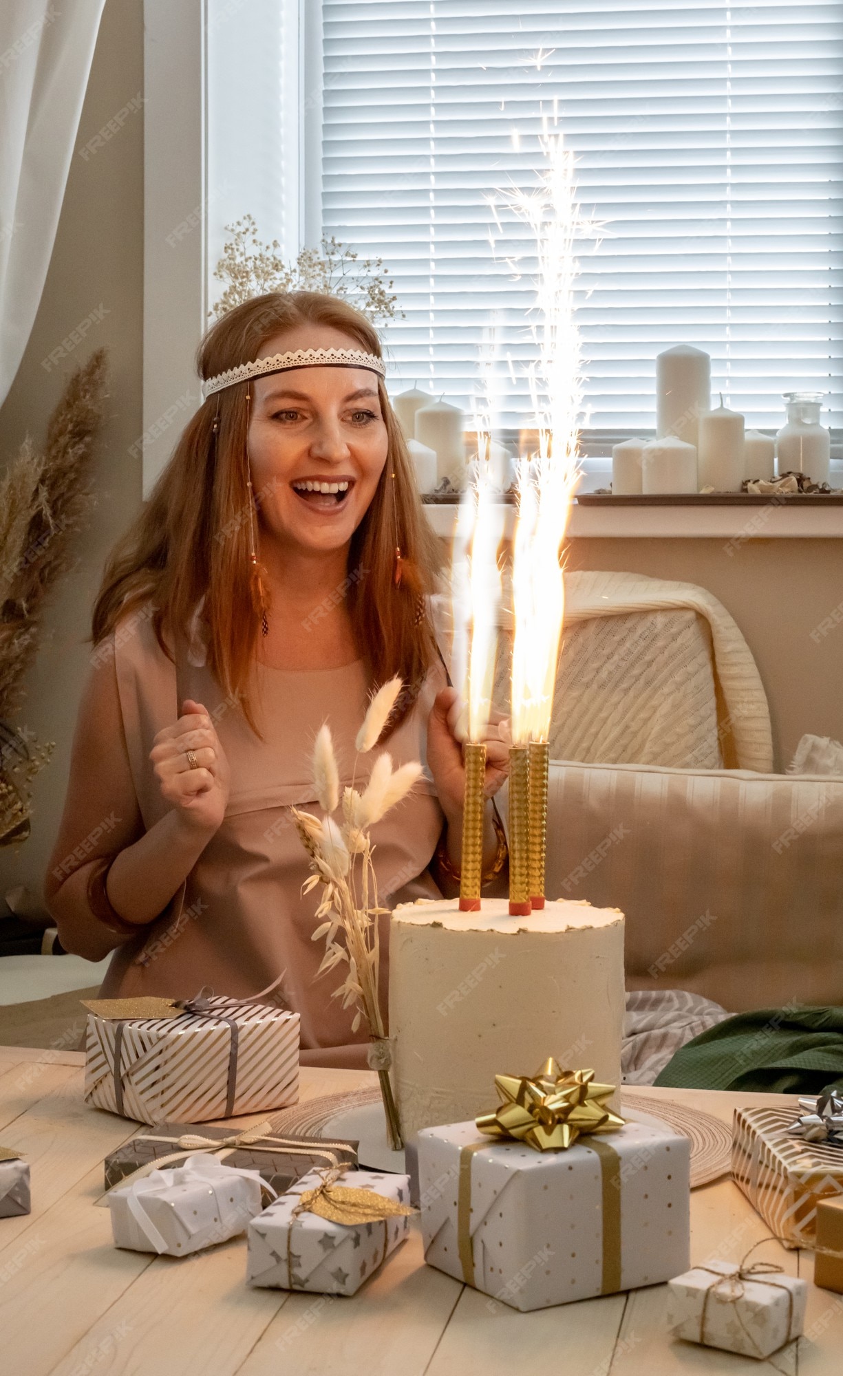 Mujer emocionada ropa de moda hippie moderna celebrando con cajas de regalo de pastel de fuego petard | Foto Premium