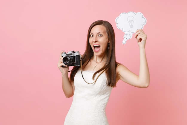 Mujer emocionada en vestido blanco mantenga cámara de fotos vintage retro, decir burbuja de discurso de nube con bombilla eligiendo personal, fotógrafo