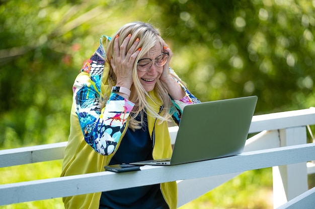 Mujer emocional con computadora portátil haciendo videollamadas y gesticulando activamente el concepto de comunicación en línea