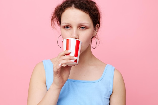 Mujer emocional de vasos desechables bebe fondo rosa