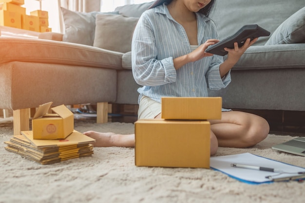 Foto mujer empaca y vende productos en línea. pequeños negocios. trabajar desde casa.sme vendiendo trabajo en concepto de casa. grupo.