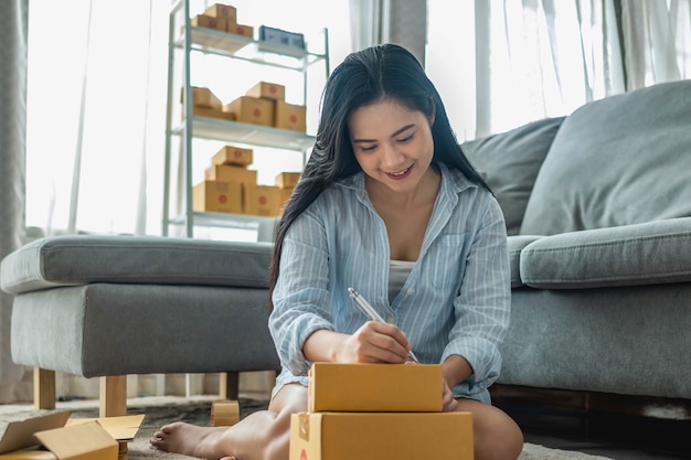 Foto mujer empaca y vende productos en línea. pequeños negocios. trabajar desde casa.sme vendiendo trabajo en concepto de casa. grupo.