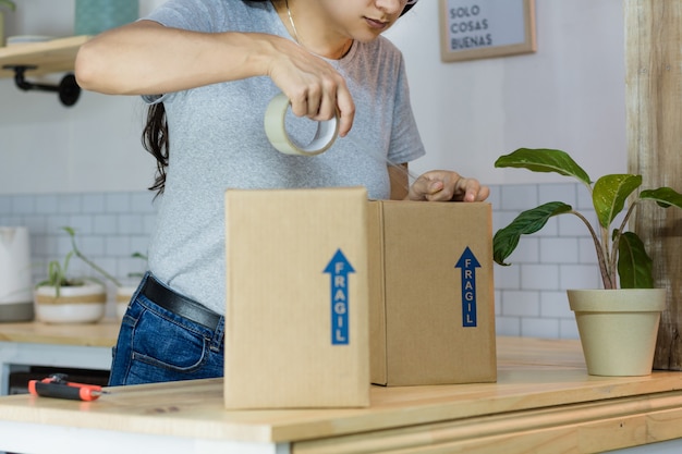 Mujer empacando un paquete para su envío