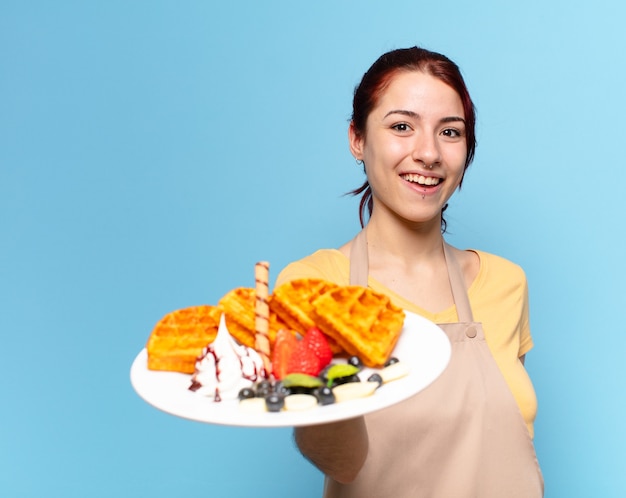 Foto mujer empleada de panadería bonita con gofres y pasteles