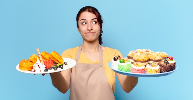 Mujer empleada de panadería tty con waffles y pasteles