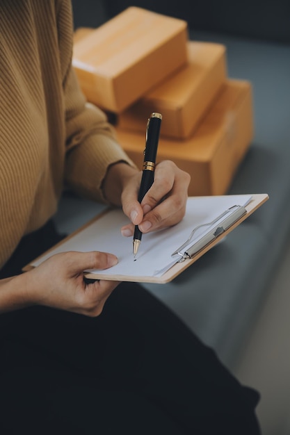 Mujer emprendedora que inicia una pequeña empresa emprendedora PYME éxito mujer freelance que trabaja en casa con entrega de paquetes en línea PYME y concepto de entrega de envases