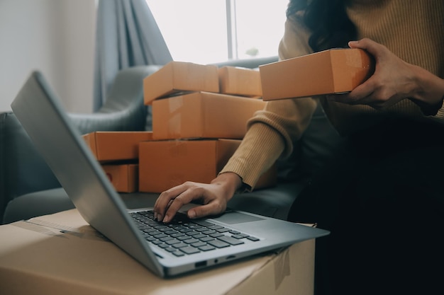 Mujer emprendedora que inicia una pequeña empresa emprendedora PYME éxito mujer freelance que trabaja en casa con entrega de paquetes en línea PYME y concepto de entrega de envases