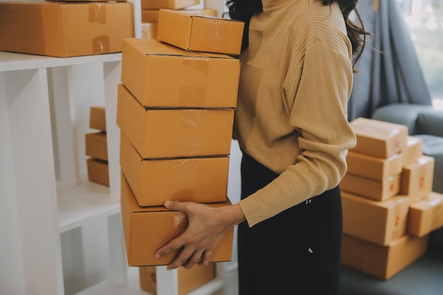 Mujer emprendedora que inicia una pequeña empresa emprendedora PYME éxito mujer freelance que trabaja en casa con entrega de paquetes en línea PYME y concepto de entrega de envases
