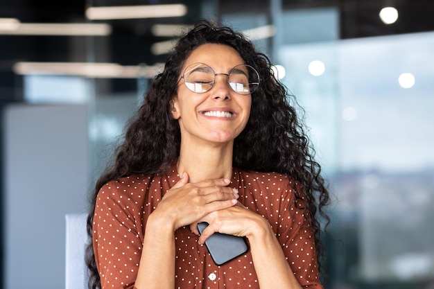 Una mujer enamorada está trabajando en la oficina en el trabajo una empresaria latinoamericana con gafas es