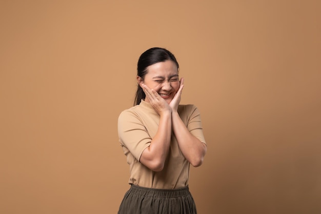 Mujer enamorada haciendo símbolo de amor aislado sobre fondo beige