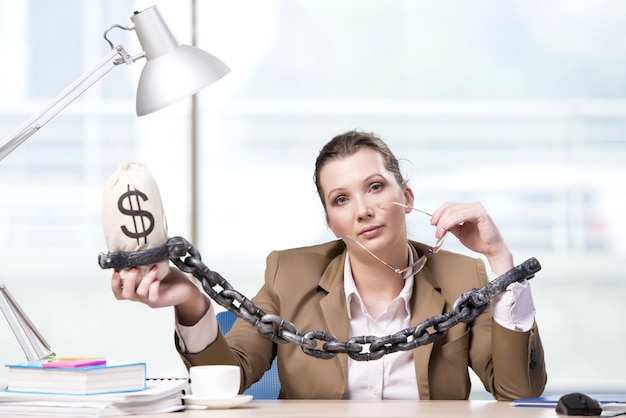 Foto mujer encadenada a su escritorio de trabajo.