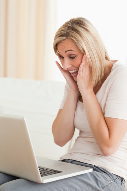 Mujer encantada mirando una computadora portátil