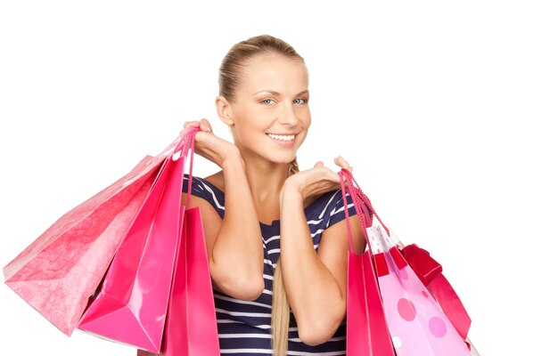 Mujer encantadora con bolsas de la compra sobre blanco