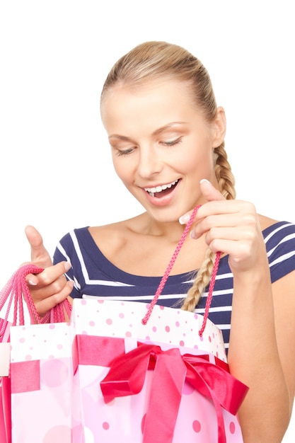 Mujer encantadora con bolsas de la compra sobre blanco