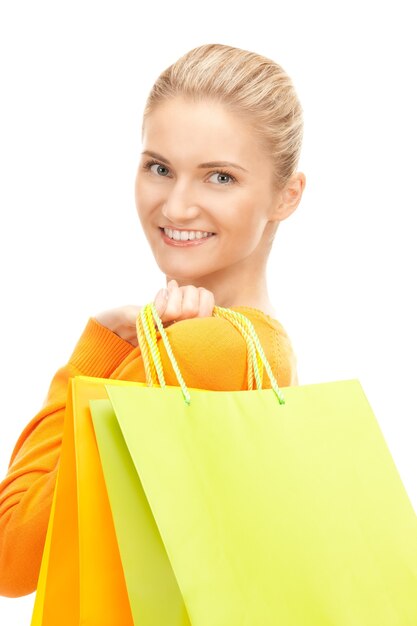 Mujer encantadora con bolsas de la compra sobre blanco