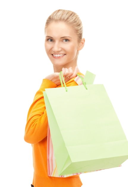 Mujer encantadora con bolsas de la compra sobre blanco