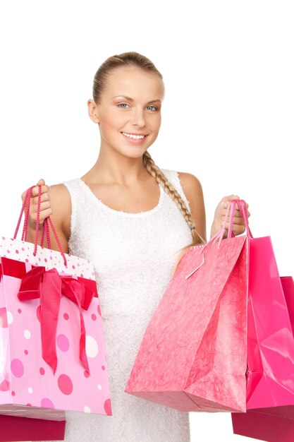 Mujer encantadora con bolsas de la compra sobre blanco