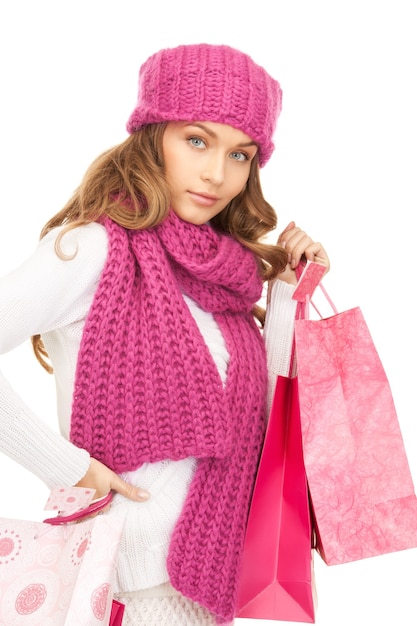 Mujer encantadora con bolsas de la compra sobre blanco