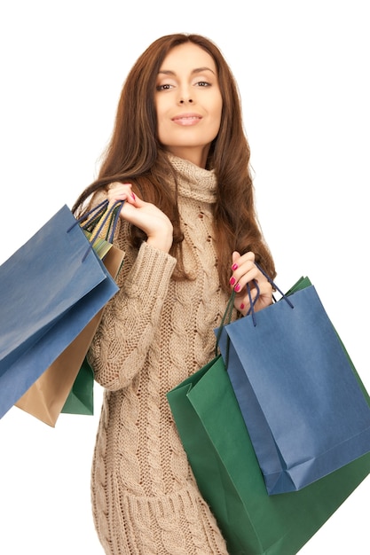 mujer encantadora con bolsas de compras sobre blanco