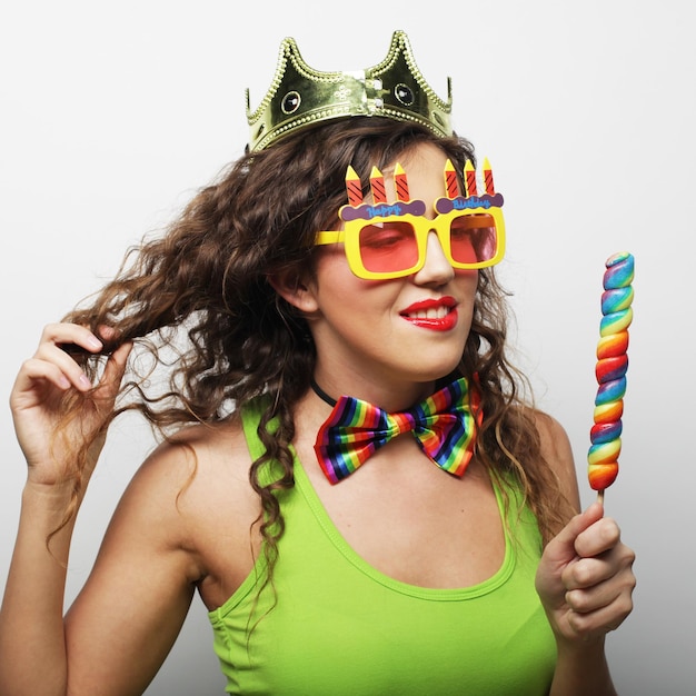 Mujer encantadora con corona y divertidas gafas de sol