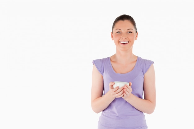 Mujer encantadora disfrutando de una taza de café mientras está de pie