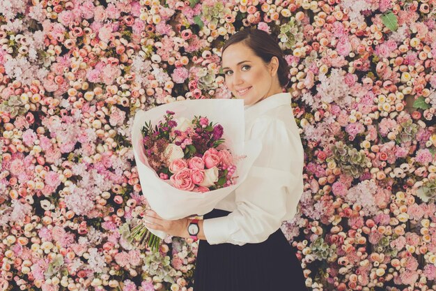 Mujer encantadora con flores en rosas rosas florales de fondo