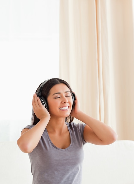 mujer encantadora con los ojos cerrados y auriculares