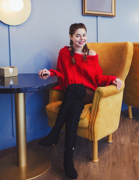 Mujer encantadora en un suéter rojo