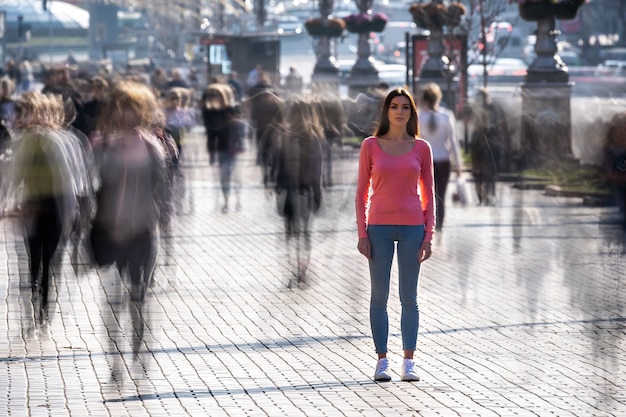 La mujer se encuentra en medio de una calle llena de gente.