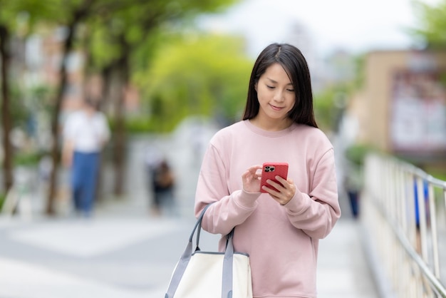 La mujer encuentra la ubicación en el teléfono móvil en la ciudad