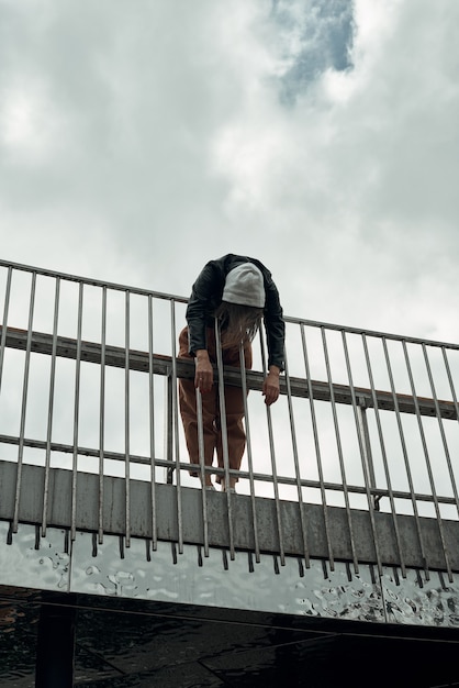 Foto mujer se encuentra en la valla del puente de la ciudad.