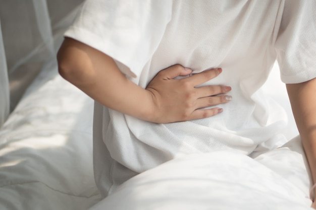 Mujer enferma con dolor de estómago o calambres menstruales