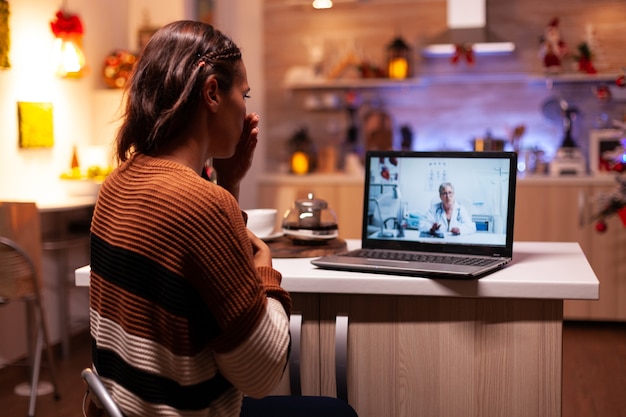 Mujer enferma hablando con el médico en la videoconferencia en línea