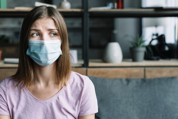 Foto mujer enferma con máscara protectora en casa