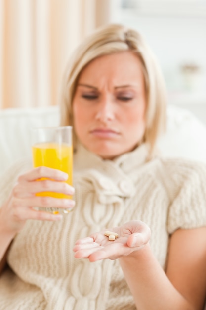 Mujer enferma que muestra pastillas