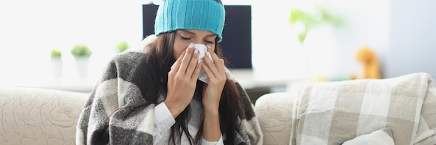 Mujer enferma con secreción nasal y use un pañuelo cubierto con una manta