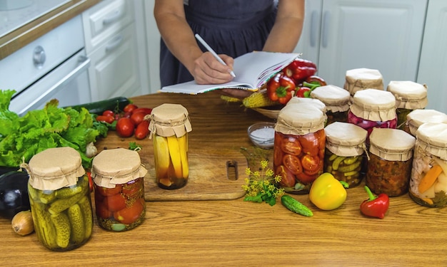 Mujer enlatando verduras en frascos en la cocina Foco selectivo