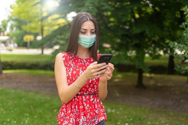 Mujer enmascarada usando su teléfono móvil