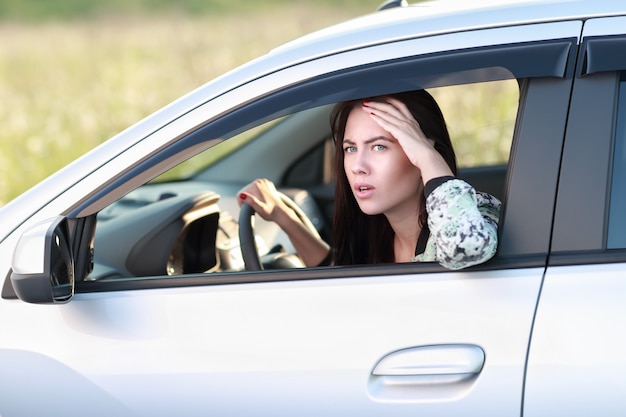 Mujer enojada disgustada conduciendo su coche. Expresión humana negativa.